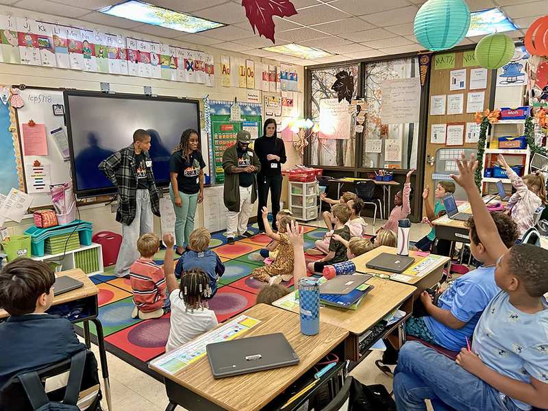 Visitors teaching the students to sign