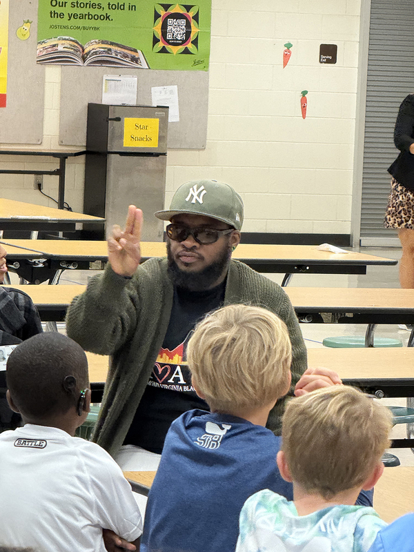 Visitors teaching the students to sign