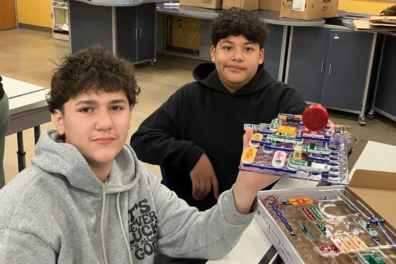 Students holding up a circuit board