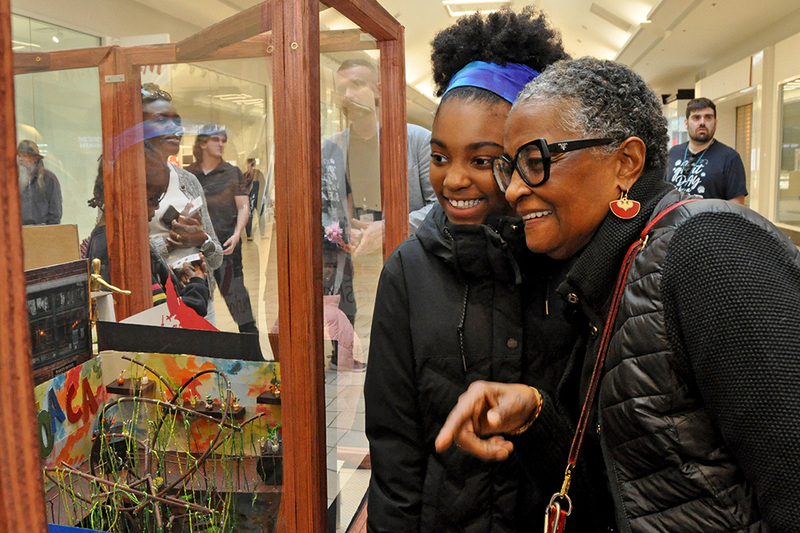 Students and parents looking at art in mall at art show