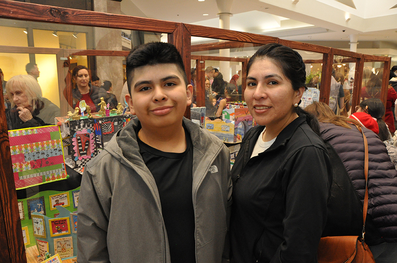 Students and parents looking at art in mall at art show