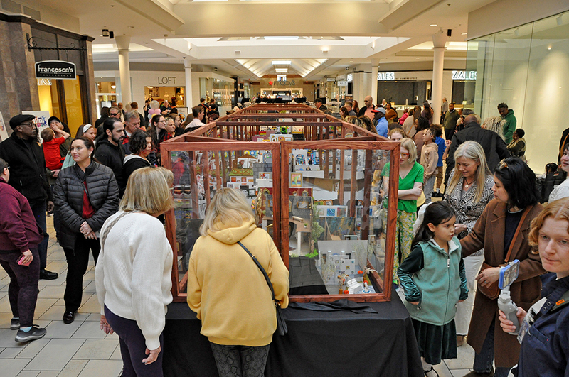 Students and parents looking at art in mall at art show