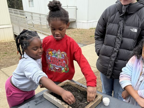 Children looking at a dirt sample