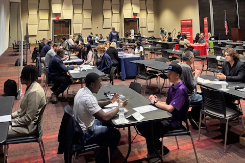 Large room with students interviewing at tables