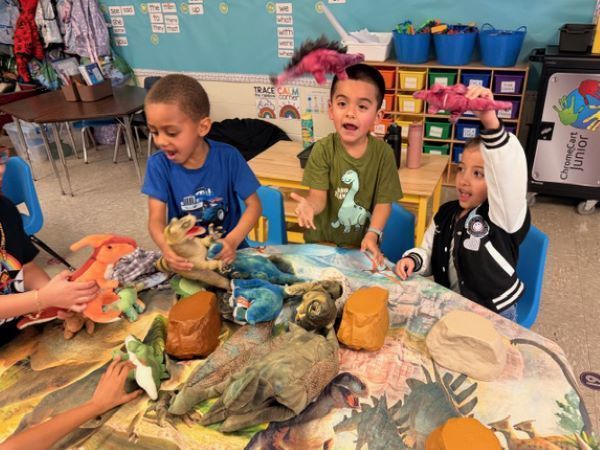 Children playing with dinosaur toys