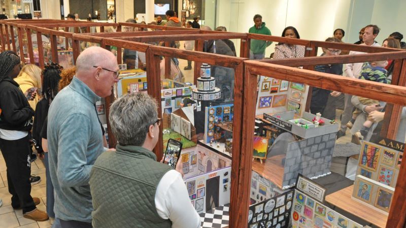 People looking at displays of miniature art
