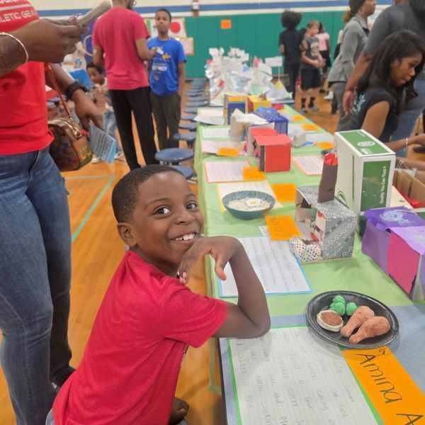 Young boy smiling at a tabke