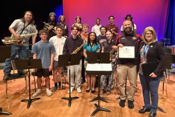Don Davis accepting an award with a group of music students