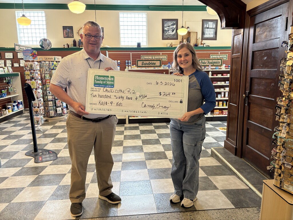 Dr. Dan Wiebers receives a check from Hometown Pharmacy for 264.25 as part of the pharmacy's Kaps for Kids program.