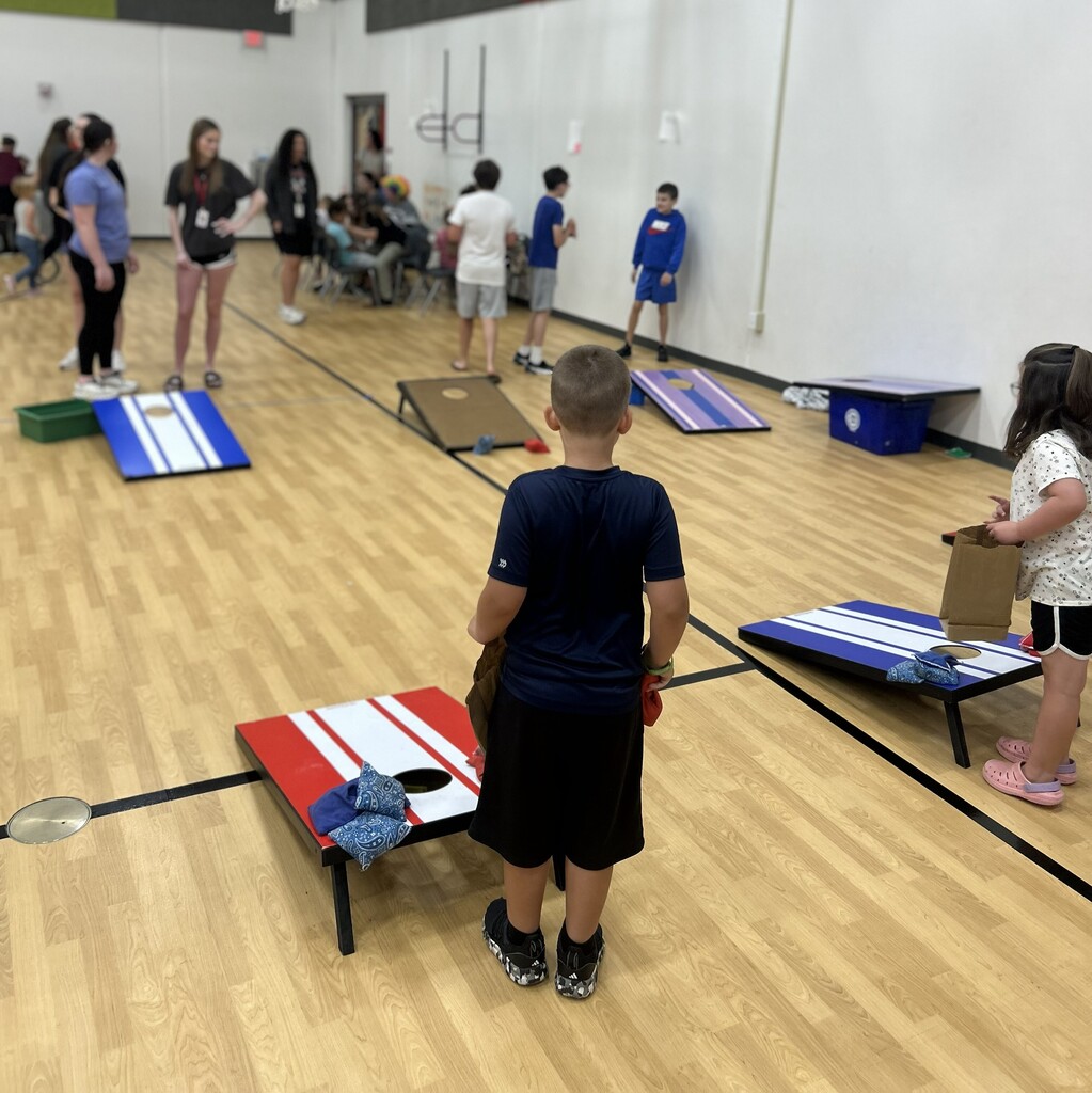 Kids play cornhole duringg the Summer School carnival
