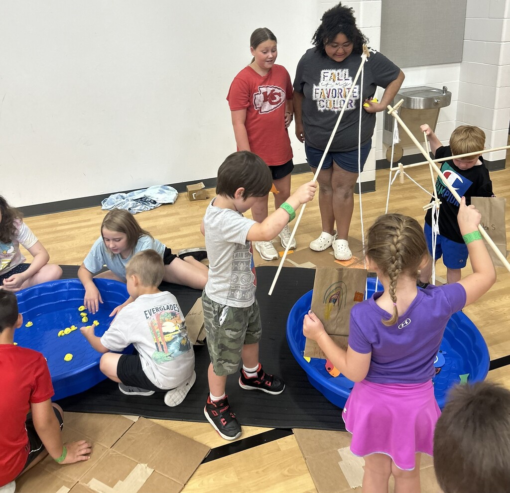 Kids play a fishing game at the Summer School Carnival