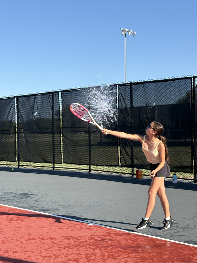 A tennis player cooling off after tennis practice Thursday by hitting a water balloon instead of a tennis ball at Danner Park tennis courts.