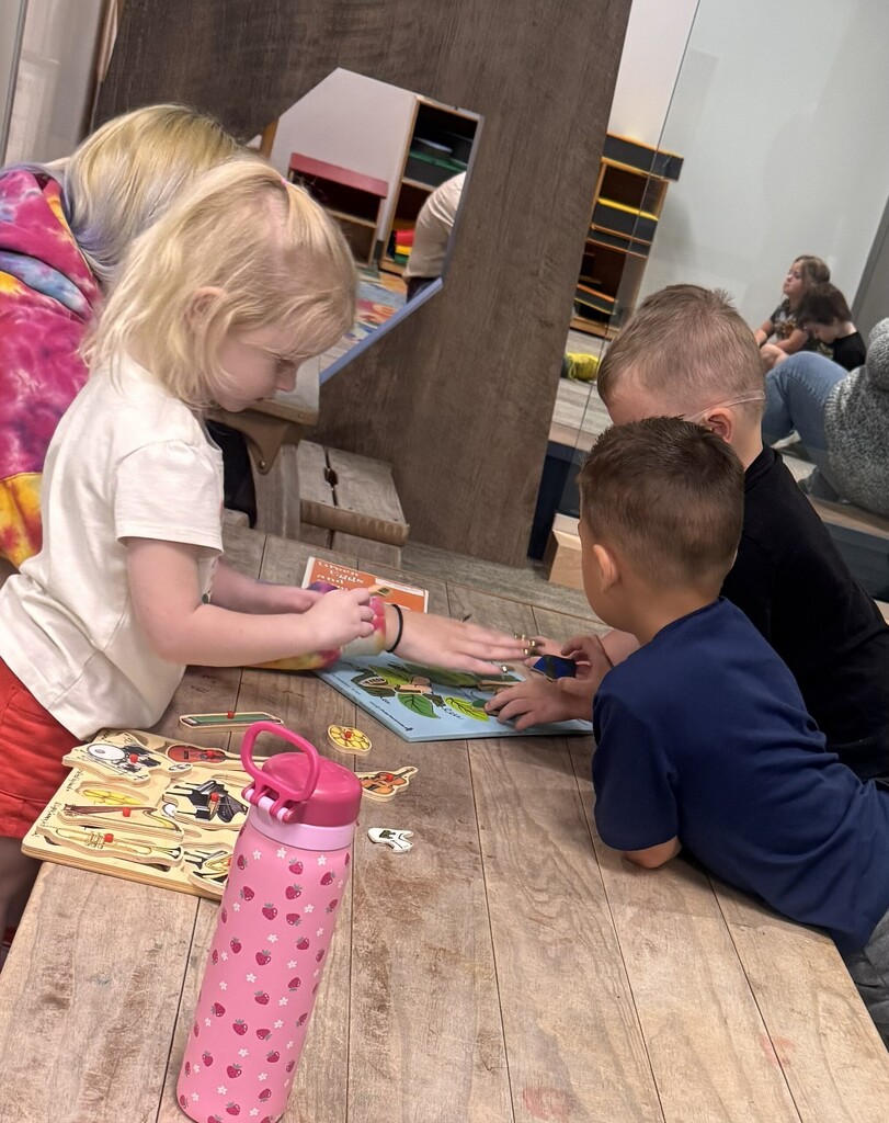 A CHS student doing puzzles with Pre-K students.