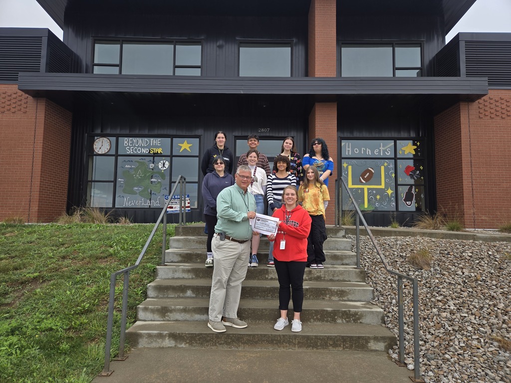 Dr. Dan Wiebers presents Bekah Anderson and her CHS Art Masters Class with a checkk to help fund a special trip for the group as a thank you for decorating the Chillicothe R-II Administrative Offices for Homecoming last week. 