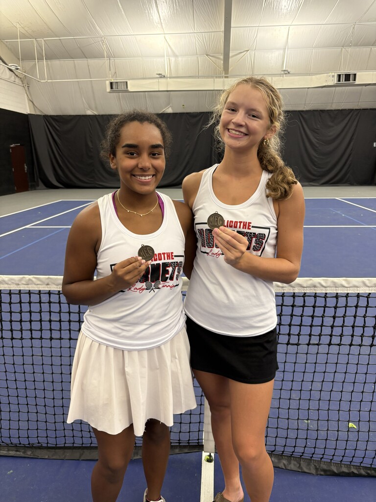 Anya Moore and Isabel Nagel - third place counference doubles team shown holding their medals on the tennis courts.