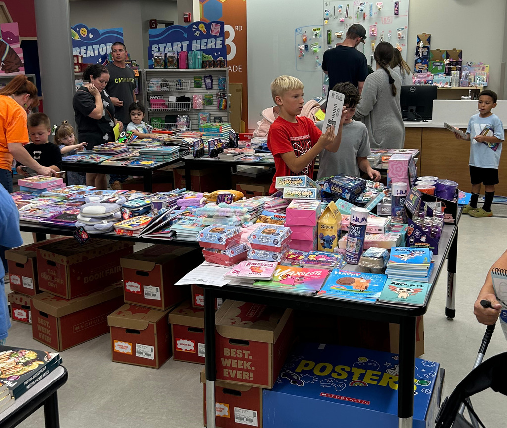 Children and parents look at the items for sale at the Book Fair held at CES last night during the Fall Famiy Night.