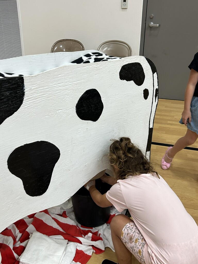 A child pretends to milk a cardboard cow during the Fall Fun Night at CES last night.