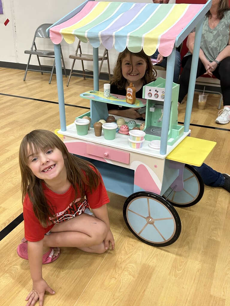 Two girls smile for the camera at an activity in the gymnasium last night.
