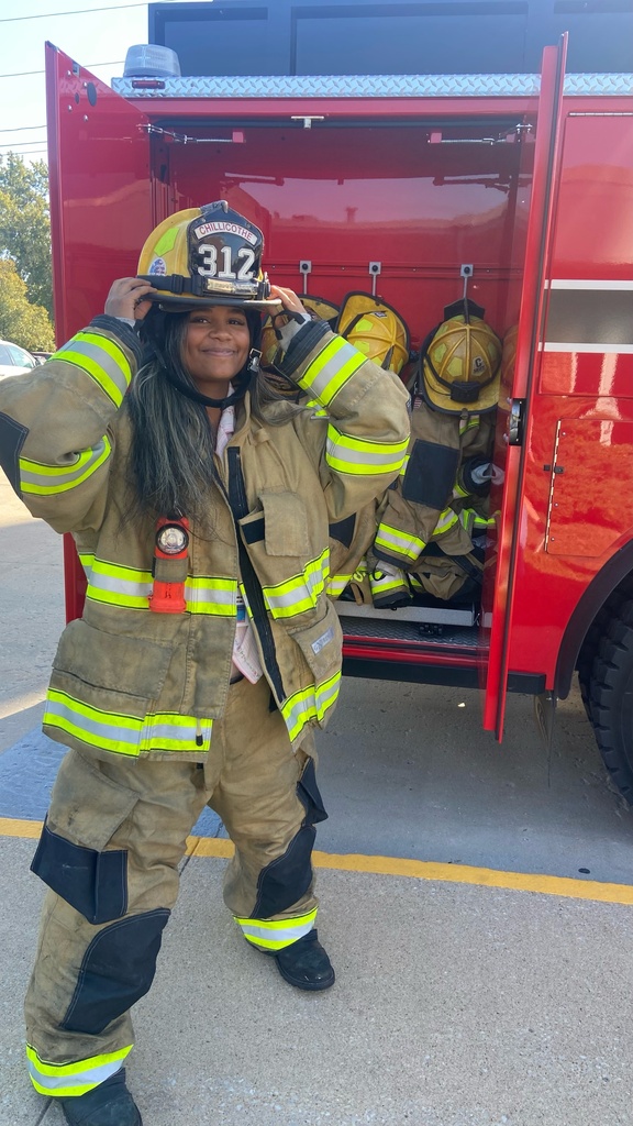 A Health Service Tech student tries on a firefighter's suit.
