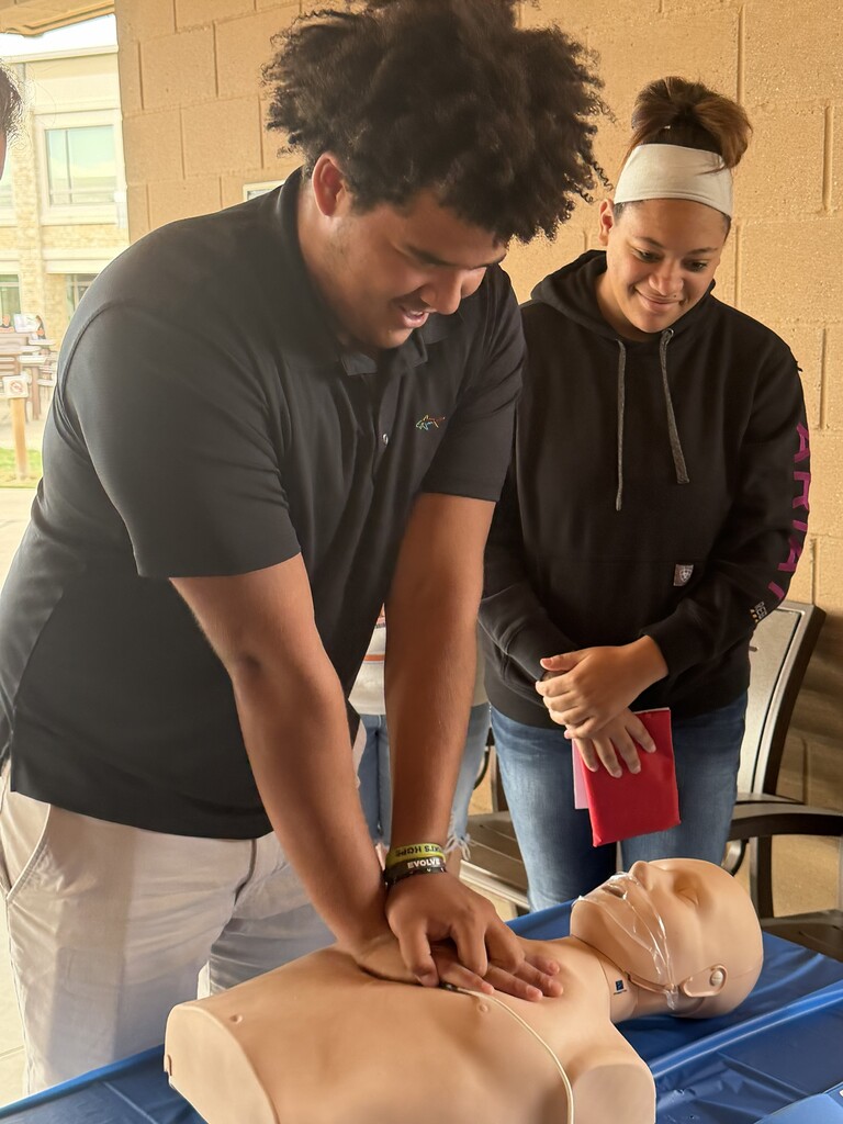 a student performs CPR on a dummy.