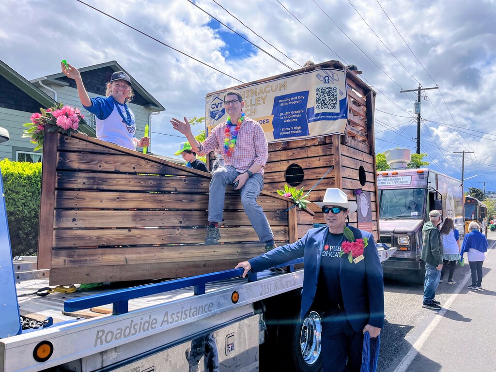Teachers waving on the student built wooden ship, riding on a flatbed truck in the Rhody Parade.
