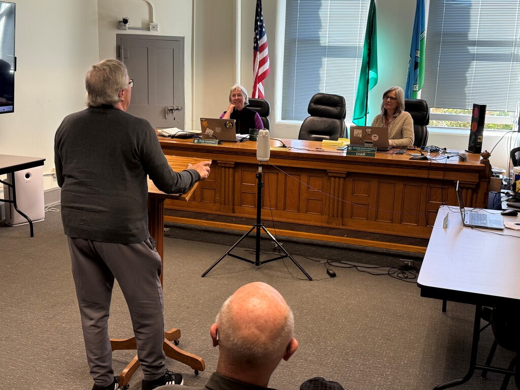 Montgomery family member stands at podium to listen to the Jefferson County Commissioners read the Proclamation.