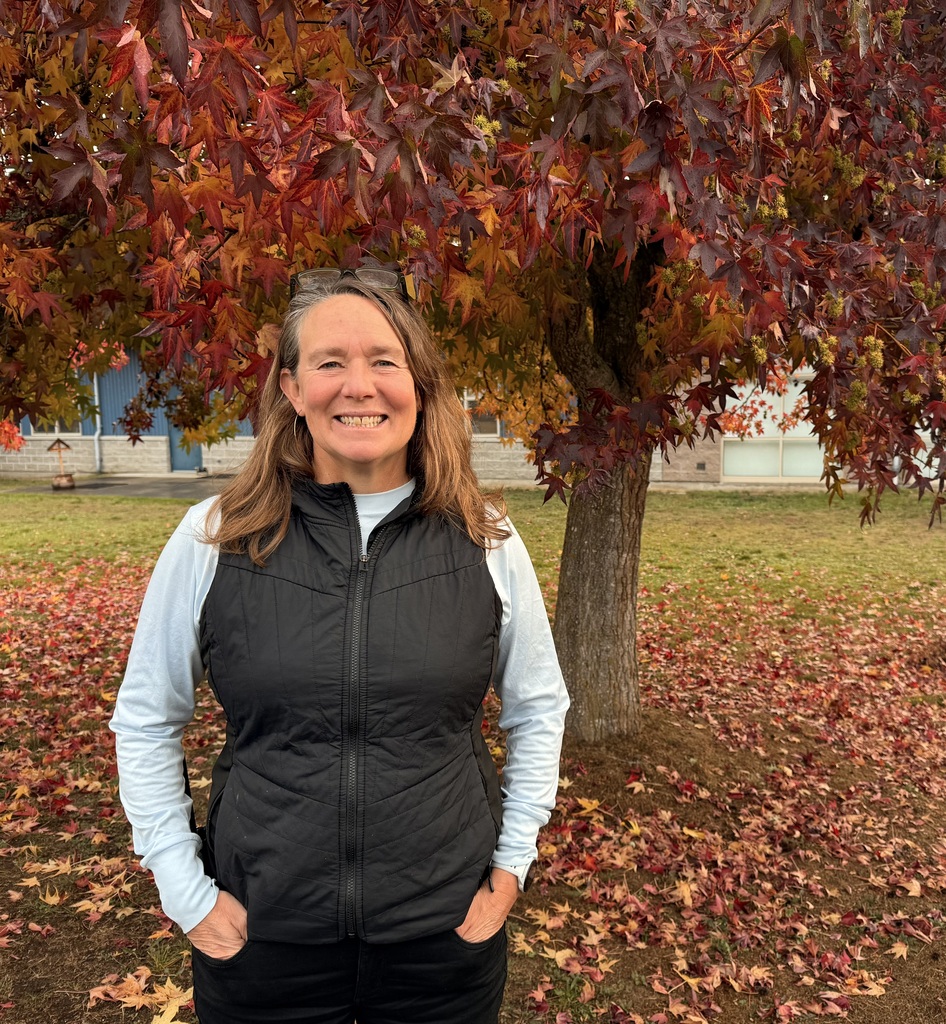 Kelley Watson standing in front of a colorful tree.