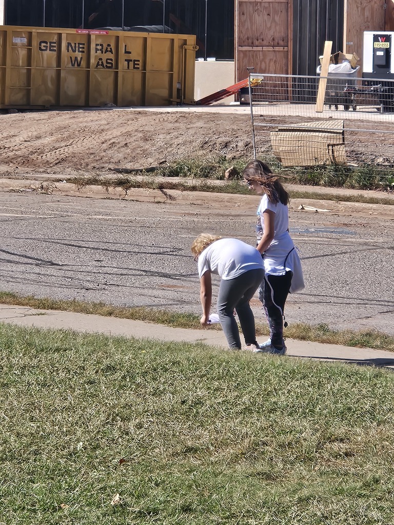 Two students finding an Ojibwe word on the side walk.