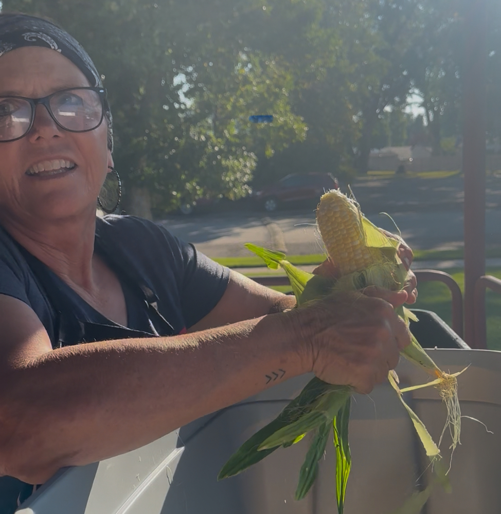 Cathy shucking corn