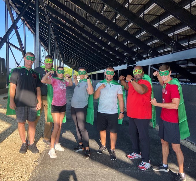 High school staff members pose as superheroes