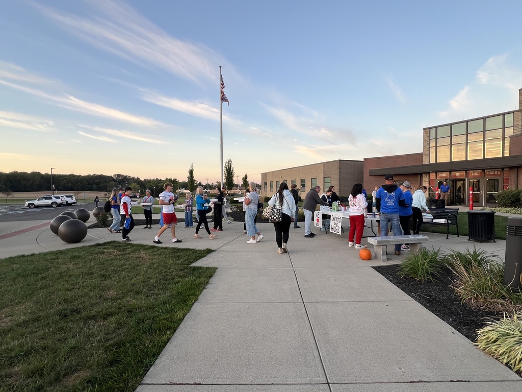 students getting donuts and hugs from parents