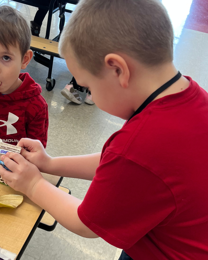 student helping to open milk