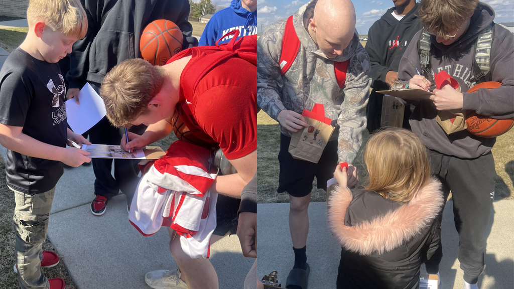 members of the varsity basketball team pose with second grade students