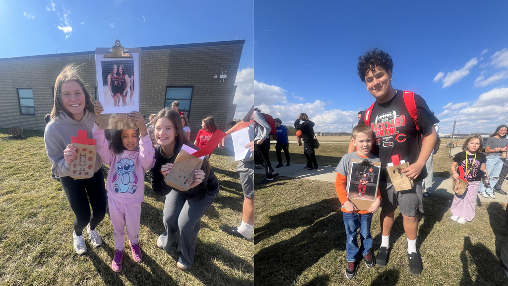 members of the varsity basketball team pose with second grade students