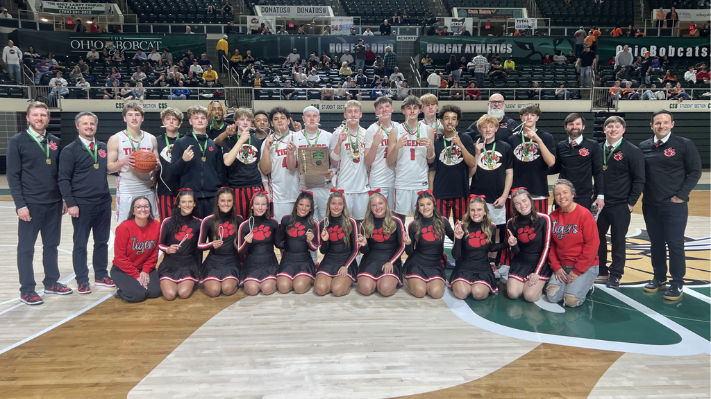 chs mens basketball team, coaches and cheerleaders pose for a group photo after winning the district championship