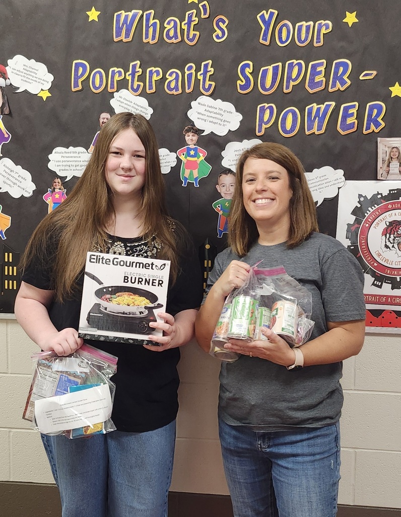 mrs paxton and student holding canned goods