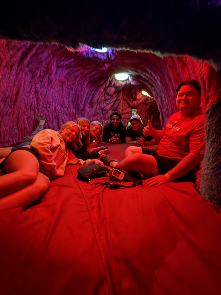 students posing in front of an art installation