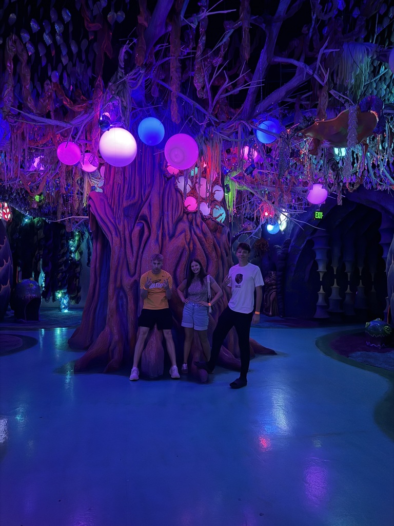 students posing in front of an art installation