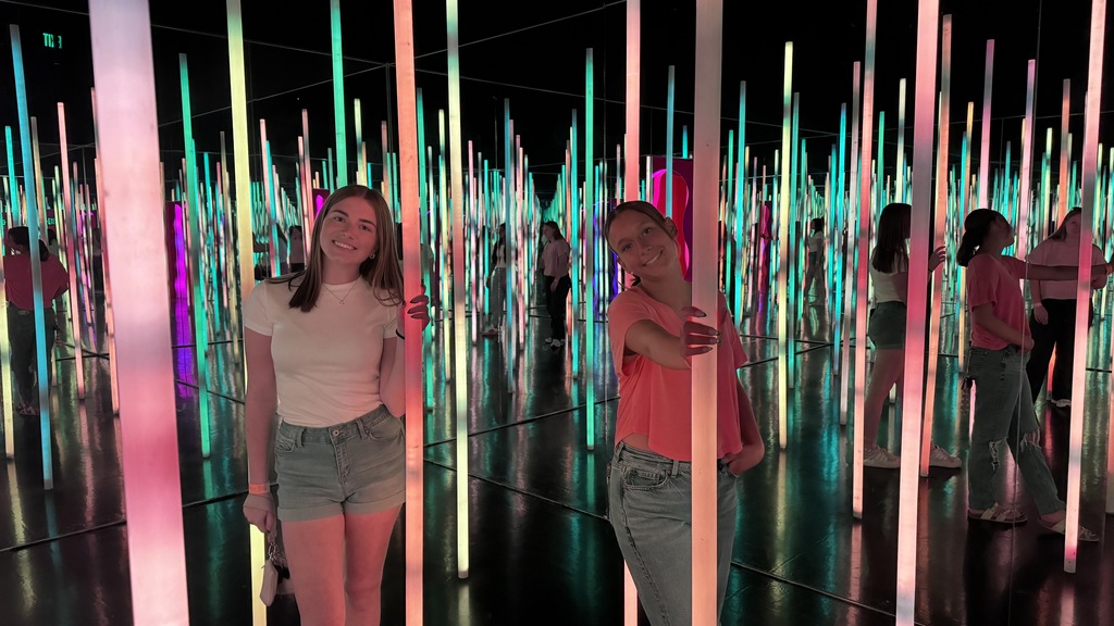 two students posing in front of an art sculpture