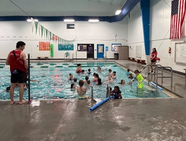 children swiming with life guard