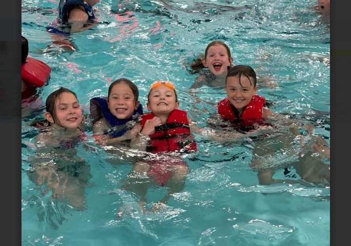 children swimming with life vests