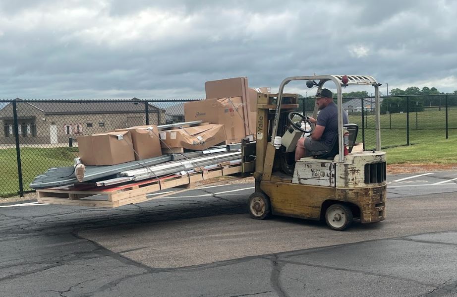 maintenance staff using fork lift to unload materials