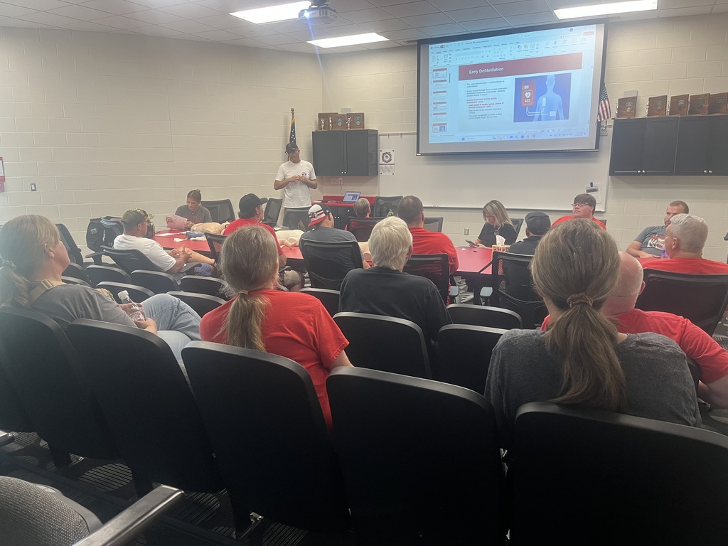 custodial staff members sit in the alumni room to get CPR certified