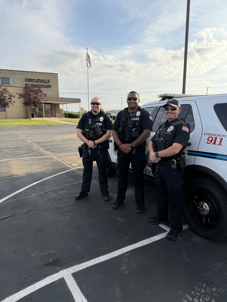 school resource officers pose in front of the buildings