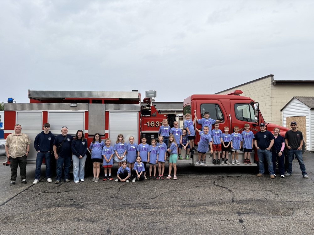 Students and members of Cissna Park Fire Protection are standing next to a fire truck.