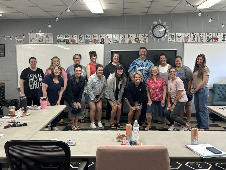 Staff stands with the presenter in a classroom