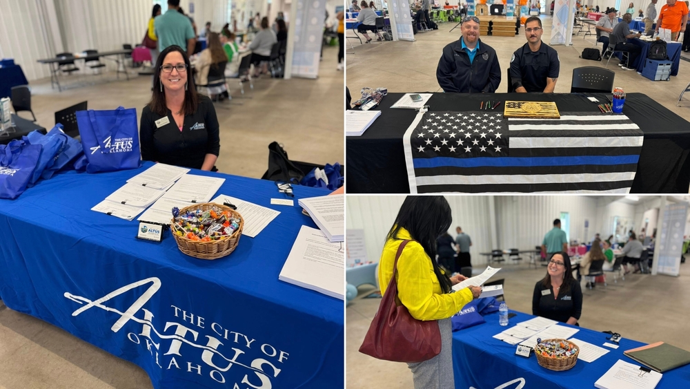 City of Altus staff members at the WORKlahoma Job Fair greeting attendees, with a table display featuring job applications, brochures, and branded materials inside the Altus Community Center.