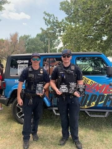 two officers holding award plaques. 