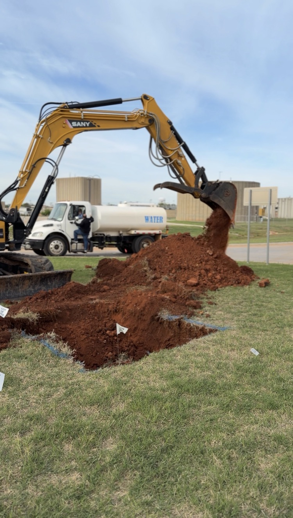 City crews conducting field measurements, excavation work with heavy equipment near utility infrastructure, and coordinated street work at an intersection in Altus.