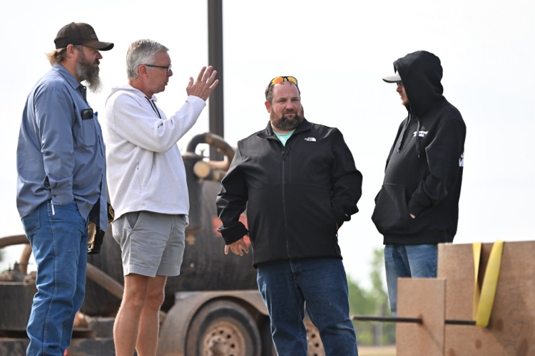 City crews conducting field measurements, excavation work with heavy equipment near utility infrastructure, and coordinated street work at an intersection in Altus.